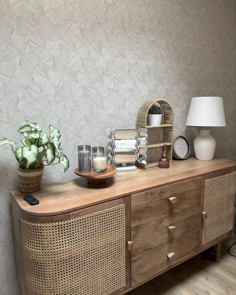La cabine des soins du corps : buffet en bois et cannage, plante, bougies, miroir et lampe