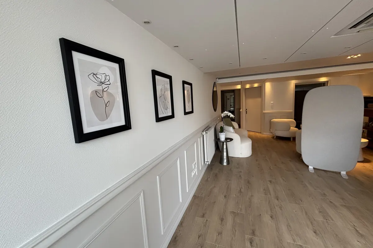 Le couloir en enfilade vers le salon, boiseries blanches et parquet clair